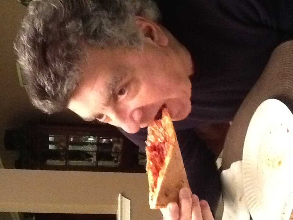 Charles enjoying a slice of pizza